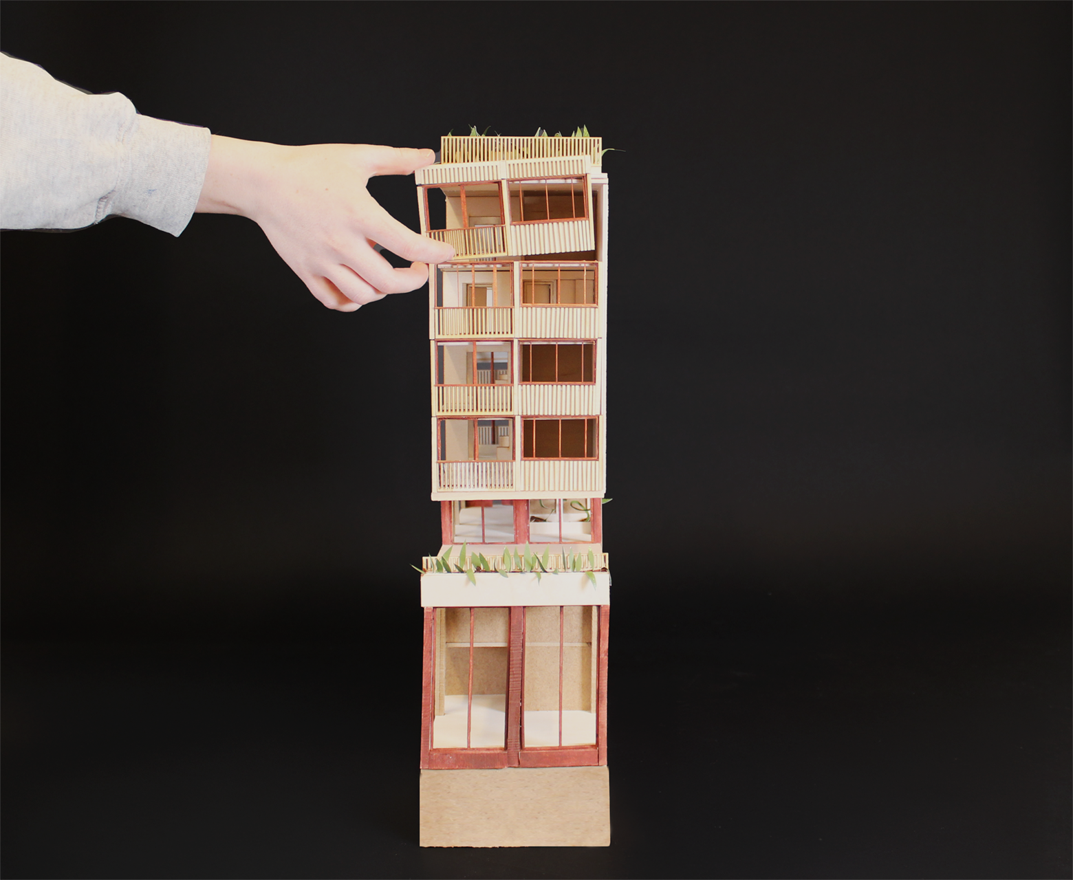 Section model 1:50. A hand is holdning a facade module, to mount it to the section model