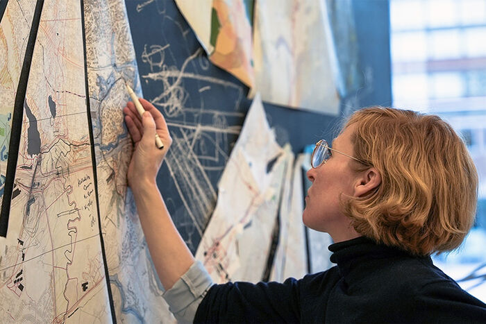 Foto av forsker ved AHO, Marja Folde som tegner på et kat på veggen 